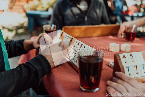 Image of A group of men drink traditional Turkish tea and play a Turkish game called Okey