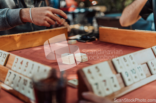 Image of A group of men drink traditional Turkish tea and play a Turkish game called Okey