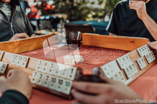 Image of A group of men drink traditional Turkish tea and play a Turkish game called Okey