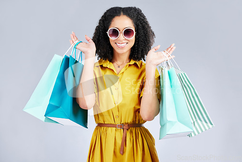 Image of Sunglasses, portrait and happy woman with shopping bag for fashion in studio isolated on a white background. Cool, sales and African customer with gift, discount deal and stylish clothes from store