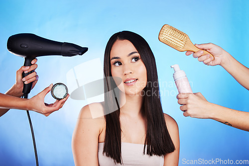 Image of Hair care, beauty and tools with a woman in studio with a hairdryer, self care product and brush. Salon, hairdresser and a female model person thinking of shampoo and cosmetics on a blue background