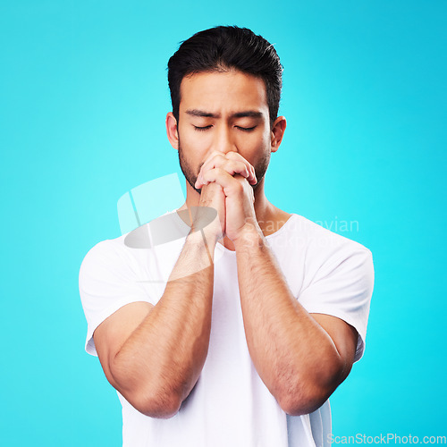 Image of Man, praying and hands in meditation or worship to God for faith or belief in spirituality, mindfulness and peace in studio. Christian, prayer and person with religion and zen on blue background