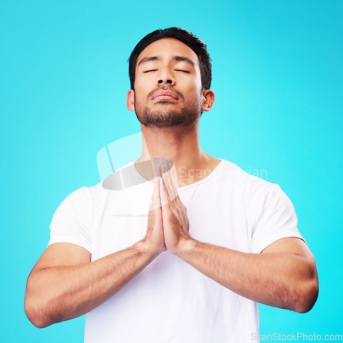 Image of Meditation, worship or man in prayer with hands and belief or faith in God for spirituality, mindfulness and peace in studio. Christian, praying and person with religion and zen on blue background