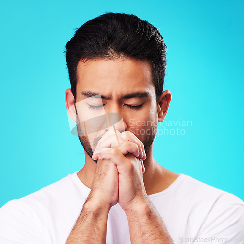 Image of Praying, hands and man in meditation or worship to God for faith or belief in spirituality, mindfulness and peace in studio. Christian, prayer and person with religion and zen on blue background