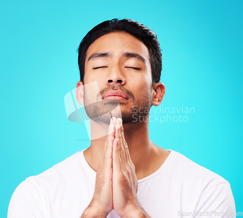 Image of Praying, man and hands in meditation or worship to God for faith or belief in spirituality, mindfulness and peace in studio. Christian, prayer and person with religion and zen on blue background