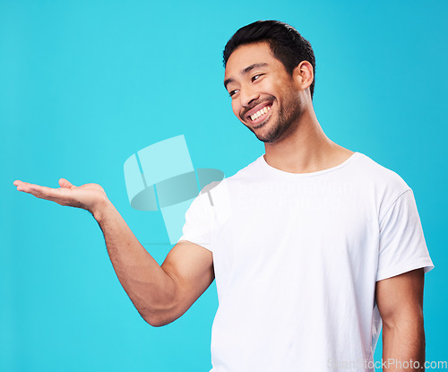 Image of Mockup, showing and man with a smile, opportunity and decision against a blue studio background. Male person, advertising or model with promotion, hand gesture or presentation with thinking or choice