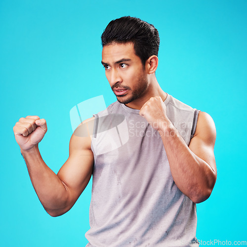 Image of Fitness, man and fight hands on blue background ,sports and workout goals with a challenge. Male person, studio and serious athlete with power, strong and energy with exercise, fighting and battle