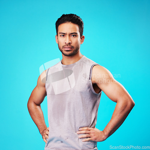 Image of Portrait, fitness and confident Asian man sweat in studio isolated on a blue background. Face, serious and personal trainer with exercise, workout or sports for healthy body or wellness in Cambodia
