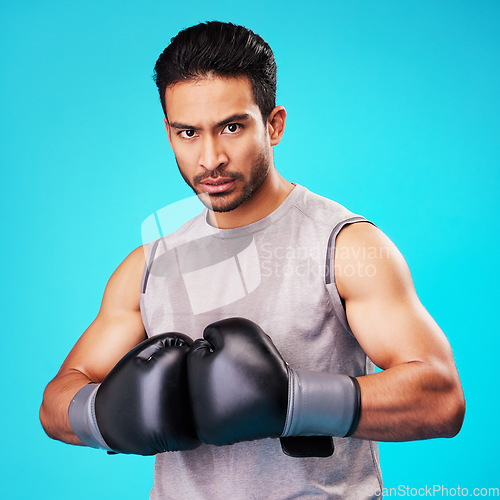 Image of Portrait, man and fighter training, boxing or challenge on a blue studio background. Male person, Asian boxer or athlete with power, strong or serious face with workout, fight or wellness with sports