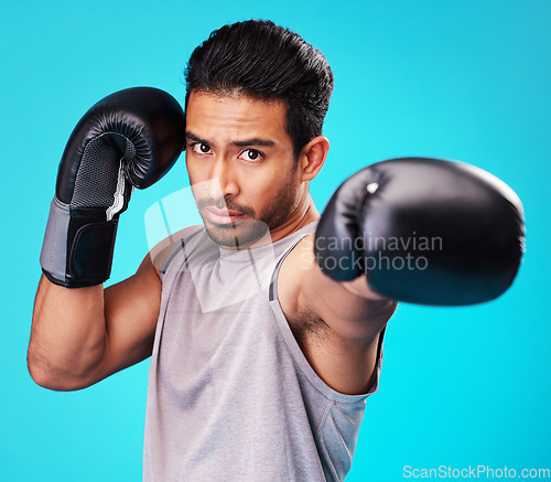 Image of Portrait, man and training with boxing, punch and sports .challenge against a blue studio background. Male person, competition and serious boxer with power, strong or energy with exercise or fighting