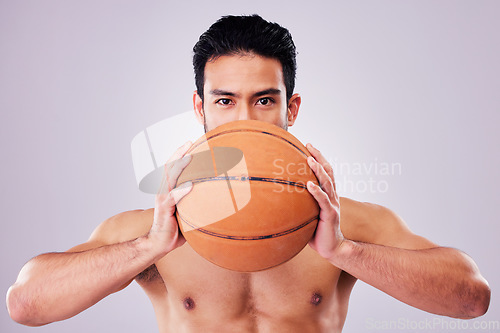 Image of Portrait, exercise and basketball with a sports man in studio on a gray background for game training. Fitness, workout or mindset and young shirtless male athlete with a ball and healthy body