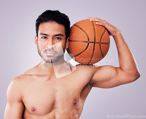 Image of Portrait, basketball and body with a sports man in studio on a gray background for training or a game. Fitness, muscle or mindset and a shirtless young male athlete holding a ball with focus