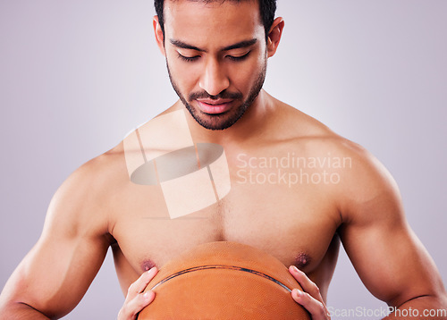 Image of Exercise, basketball and a shirtless sports man in studio on a gray background for training or a game. Fitness, workout or mindset and a young male athlete holding a ball with focus or confidence