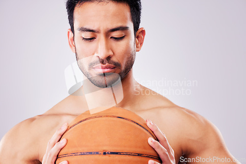 Image of Fitness, basketball and a shirtless sports man in studio on a gray background for training or a game. Exercise, workout or mindset and a young male athlete holding a ball with focus or confidence