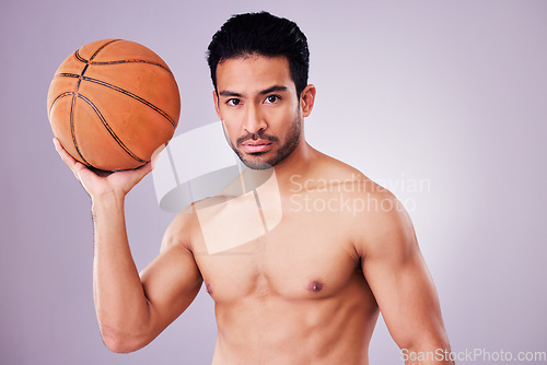 Image of Portrait, basketball and focus with a sports man in studio on a gray background for training or a game. Fitness, body or shirtless and a young male athlete holding a ball with focus or confidence