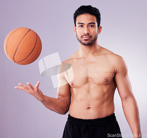 Image of Portrait, sports and basketball with a man in studio on a gray background for training or a game. Exercise, workout or mindset and a confident young male athlete with a ball for a competitive hobby