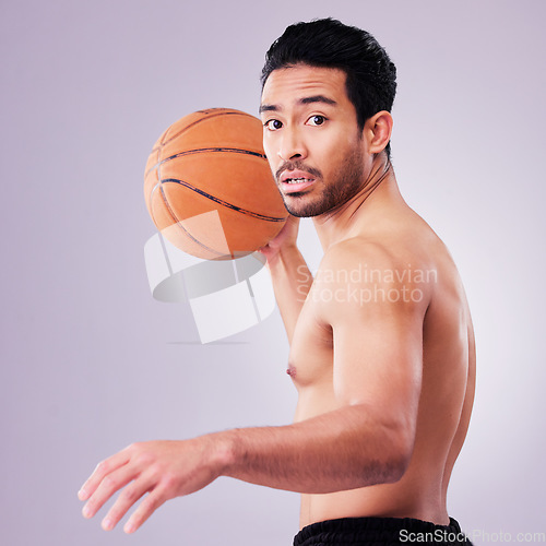 Image of Portrait, playing basketball and a sports man in studio on a gray background for training or a game. Exercise, workout or mindset and a young male athlete holding a ball to play a competitive match