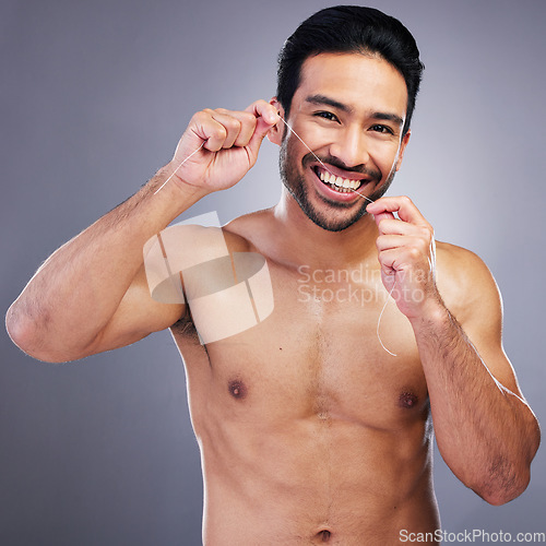 Image of Teeth cleaning, floss and studio portrait of happy man with oral hygiene, self care or tooth treatment string. Mouth plaque routine, aesthetic smile and person with dental product on gray background