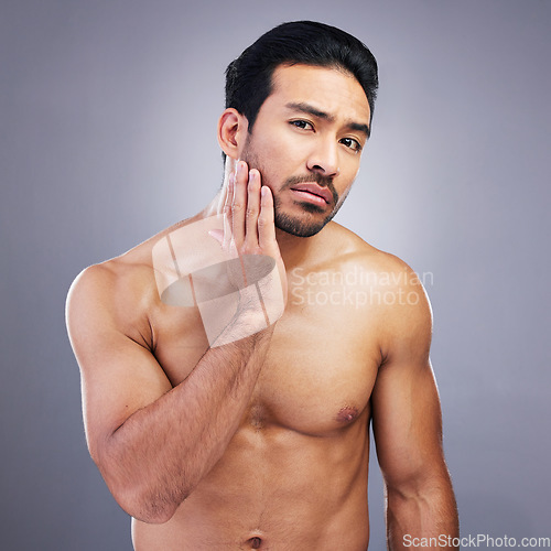 Image of Portrait, skincare and man with beauty, cosmetics and frustrated against a grey studio background. Face, male person and model with grooming routine, unhappy and facial with wellness, shine and sad