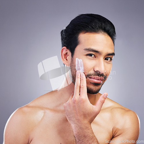 Image of Skincare portrait, cream and studio man with facial cleaning routine, morning hydration or spa self care. Bathroom cosmetics, face lotion product and aesthetic person wellness on gray background