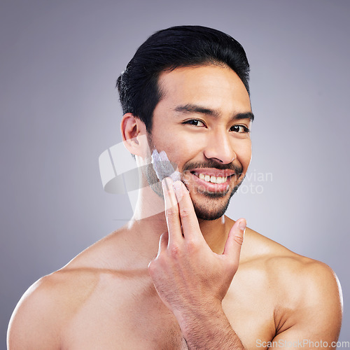 Image of Cosmetics, skincare or portrait of happy man with face cream or sunscreen product in grooming routine. Dermatology, studio background or confident Asian model smiling or applying facial creme lotion