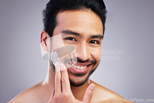 Image of Smile, portrait or happy man with shaving cream or beard product in grooming routine with cosmetics. Beauty, studio background or Asian male model applying hair removal creme lotion for skincare