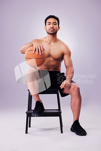 Image of Portrait, fitness and basketball with a man on a chair in studio on a gray background for training or a game. Exercise, workout or mindset and confident young male sports athlete sitting with a ball