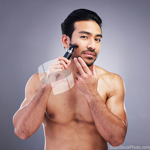 Image of Beard hair, trimmer and portrait of man with bathroom routine, wellness grooming and cosmetics skincare. Morning face cleaning, facial growth maintenance and studio person shaving on grey background
