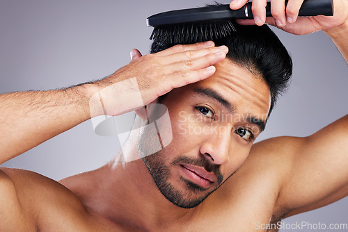 Image of Portrait, beauty or man brushing hair in grooming with salon haircare product on studio background. Natural person, brush or confident healthy Asian male model with cool hairstyle in morning routine