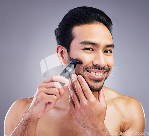 Image of Beard hair trimmer, portrait and man smile for bathroom shaving routine, grooming or morning skincare. Studio razor, facial growth maintenance and Mexican person with clean face on gray background