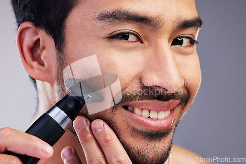 Image of Beard hair trimmer, happiness and man portrait for bathroom shaving, blade grooming or morning beauty routine. Studio razor, facial cleaning and closeup person with fresh face glow on gray background