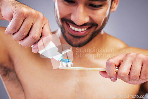 Image of Toothpaste, dental or happy man brushing teeth with smile or healthy oral hygiene grooming in studio. Eco friendly, tube product or male model cleaning mouth with a natural bamboo wood toothbrush