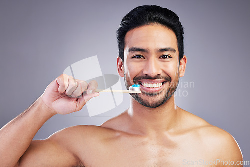 Image of Smile, portrait and a man brushing teeth on a studio background for cleaning, grooming and hygiene. Happy, wellness and an Asian person with a toothbrush for care of mouth isolated on a backdrop