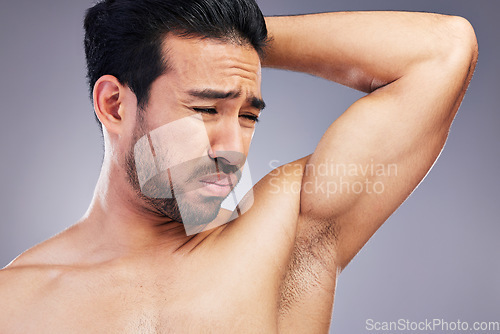 Image of Armpit, smell and man with body odor in studio isolated on a white background for deodorant, cleaning and skincare cosmetic. Underarm, bad stink and model with hyperhidrosis, sweating or poor hygiene
