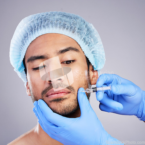 Image of Hands, face and plastic surgery with a man in studio on a gray background for a botox injection. Needle, beauty and transformation with a male customer in a clinic for antiaging filler or cosmetics
