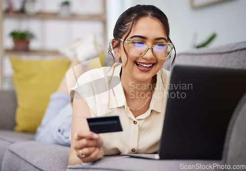 Image of Happy woman, credit card and money with laptop on sofa for ecommerce payment, fintech password and online shopping. Female customer, computer and banking code for financial sales promotion at home