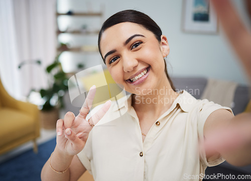 Image of Happy woman, portrait and peace for selfie in home, video call or live streaming vlog in living room. Face of young female gen z show v sign, hand emoji and memory for social media or profile picture