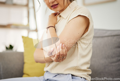 Image of Elbow, injury and hand of woman on a sofa with problem, arthritis or osteoporosis in her home. Arm, pain and female with joint, crisis or fibromyalgia in a living room with muscle tension or accident