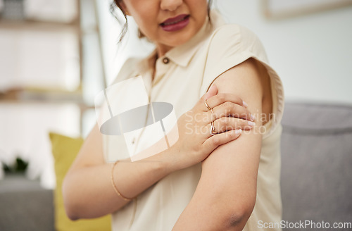 Image of Shoulder, injury and hand of woman on sofa with problem, arthritis or osteoporosis in her home. Arm, pain and female with joint, crisis or fibromyalgia in living room with muscle tension or accident