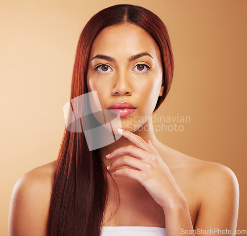 Image of Hair care, natural beauty and portrait of serious woman, hand on skin and luxury salon treatment on brown background. Aesthetic, haircut and haircare, face of model for cosmetics and makeup in studio