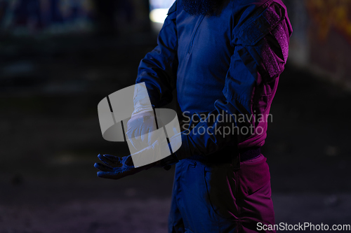 Image of Modern warfare soldier checking navigation, time and other information on a smartwatch. Dark night black background.