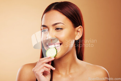 Image of Thinking, cucumber and woman with skincare, dermatology and cosmetics on a brown studio background. Female person, healthy fruit and model with wellness, glow and beauty with shine, natural and ideas