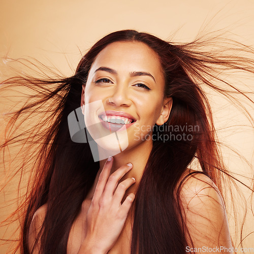 Image of Hair care, beauty and portrait of happy woman with wind, luxury salon treatment and brown background. Smile, haircut and haircare, face of model with natural cosmetics and keratin shine in studio.