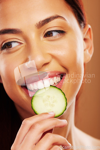 Image of Thinking, cucumber and woman with skincare, natural beauty and cosmetics on a brown studio background. Female person, healthy fruit and model with wellness, glow and dermatology with shine and ideas