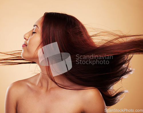 Image of Woman, shake hair and beauty with texture, cosmetics and grooming against a brown studio background. Female person, wind and model with shine, natural treatment or aesthetic with confidence or luxury