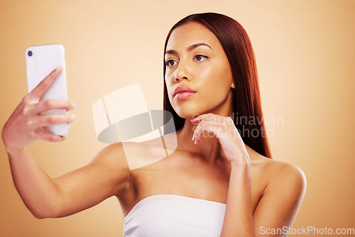 Image of Studio, beauty or selfie with woman on social media to post picture or photo online on internet blog. Pictures, girl influencer or female model isolated on brown background for skincare or self care