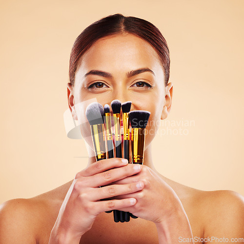 Image of Makeup, brush and portrait of woman with cosmetic beauty product for skincare isolated in a studio brown background. Happy, elegant and powder for cosmetology aesthetic, glow and soft skin glamour