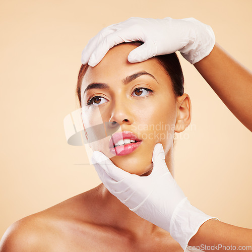 Image of Hands, plastic surgery or facelift for woman in studio ready for laser, filler implant or beauty transformation. Skincare consultation, facial or gloves for change or liposuction on brown background
