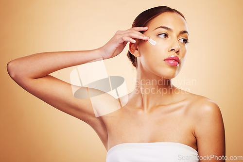 Image of Skincare, beauty and a woman with cream on a studio background for wellness and moisture. Cosmetics, product and a young girl or model with lotion or sunscreen for facial skin health on a backdrop