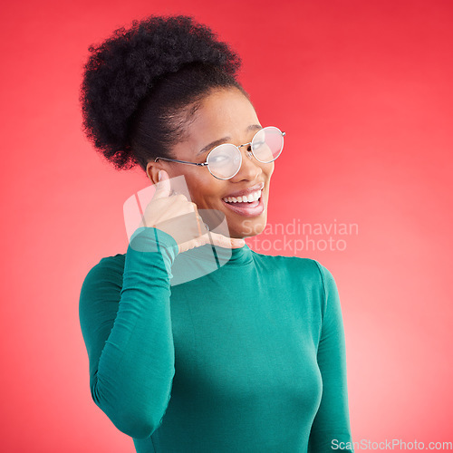 Image of Call me, woman and portrait in studio with model and phone hand gesture for talk. Red background, happy female person and flirting with speaking, mobile and contact icon and sign with a smile